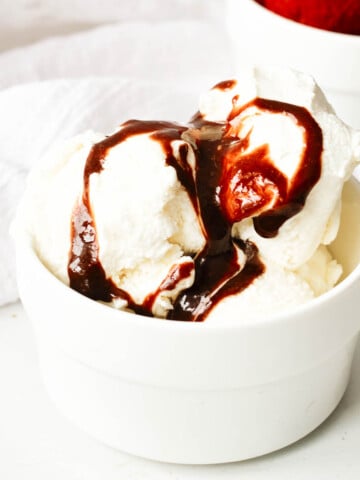 vegan chocolate sauce over vanilla ice cream in white bowl