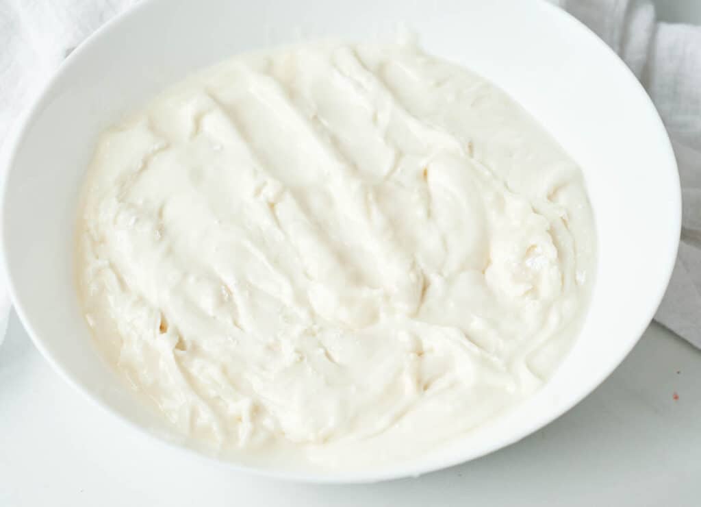 whipped vegan cream cheese frosting in white bowl
