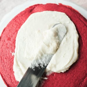 vegan cream cheese frosting on red velvet cake layer