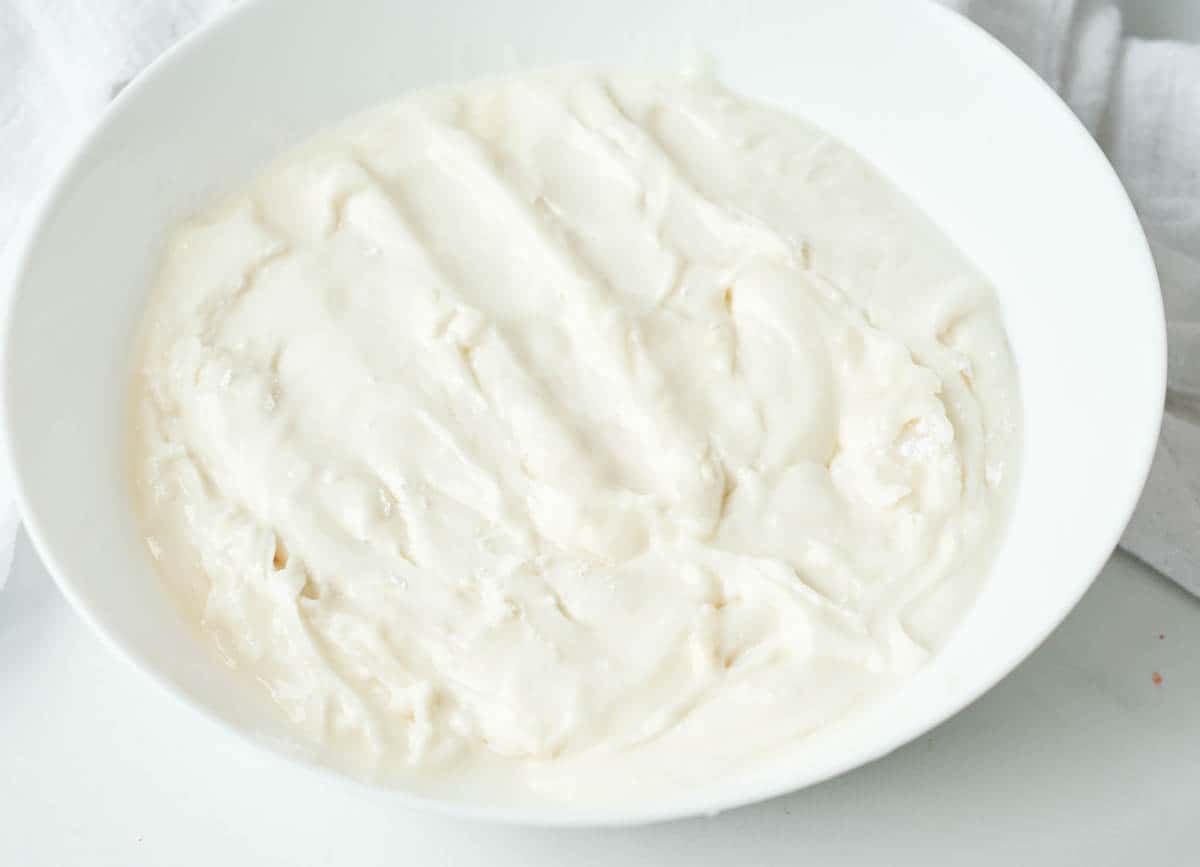 Vegan cream cheese frosting in white bowl.

