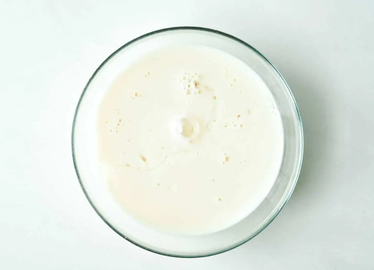 Soy milk and vinegar combined in glass bowl.
