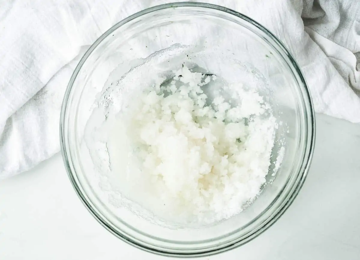 Coconut oil and sugar creamed together in glass bowl.
