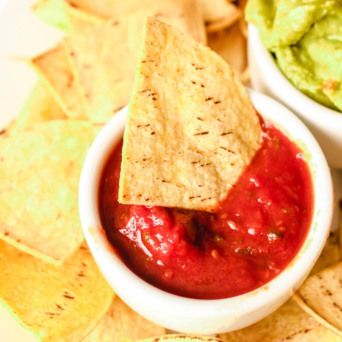 air fryer tortilla chip dipped in bowl of salsa