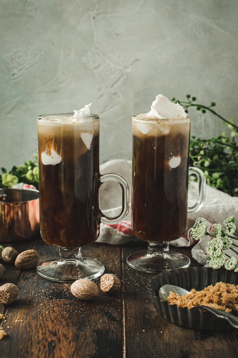 two vegan Irish coffees in glass mugs topped with coconut whipped cream