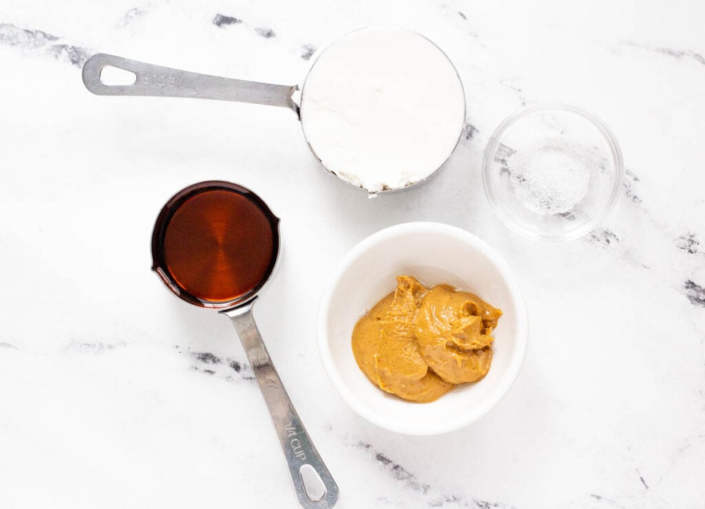 coconut cream, and maple syrup in measuring cups, salt and nut butter in small bowls on counter top