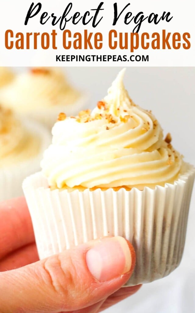 hand holding vegan carrot cake cupcake with cream cheese frosting