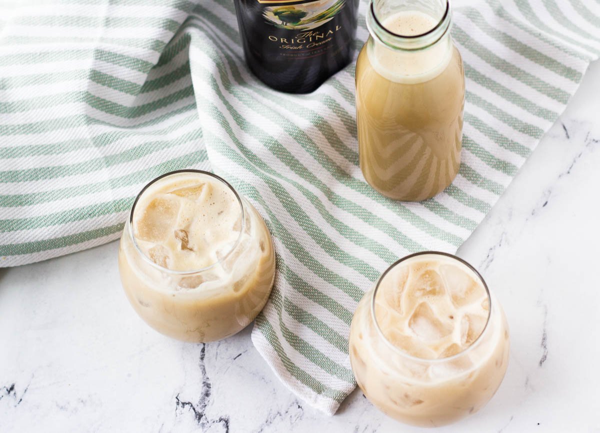 vegan Irish cream in stemless wine glasses with Bailey's bottle in the background