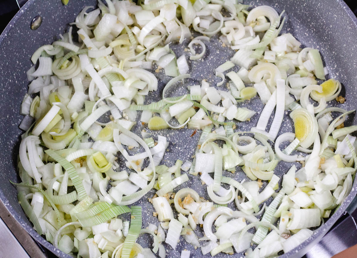 Leeks, onions, and garlic in sautéing in pot.