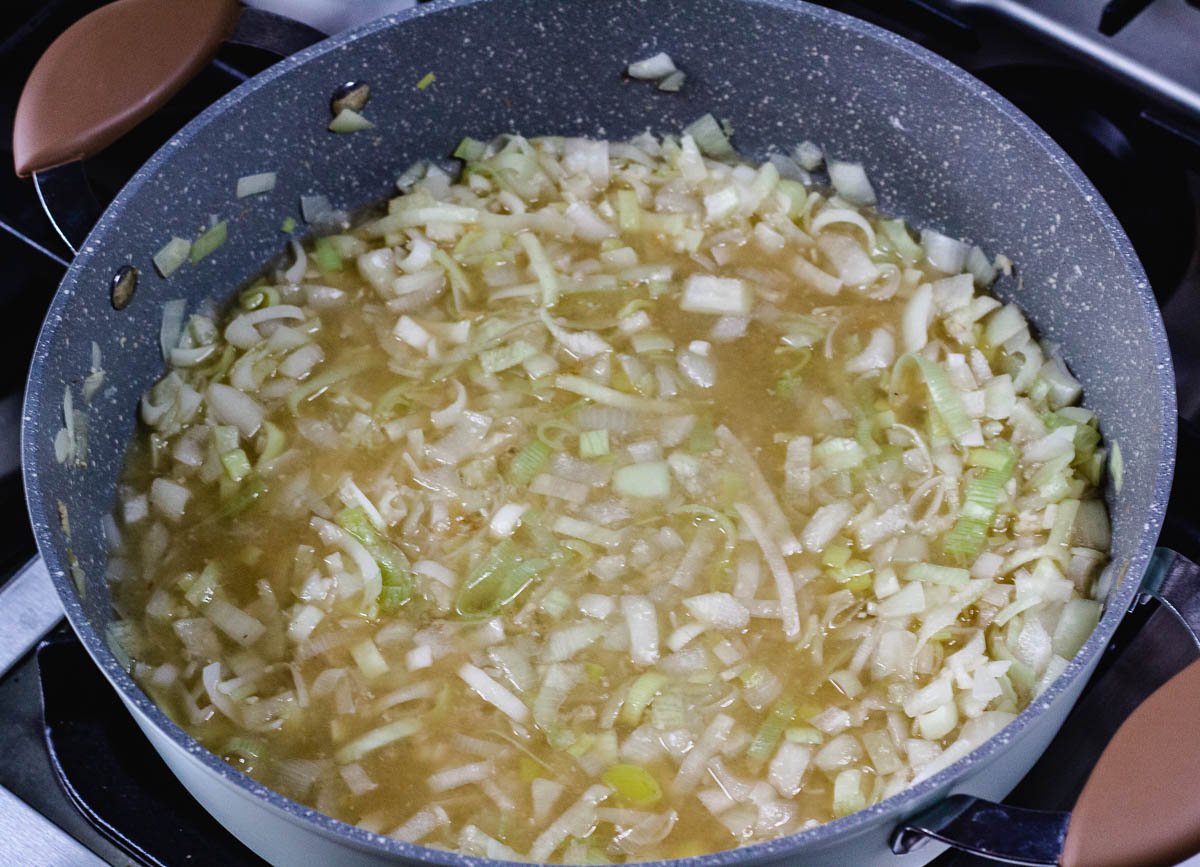 Leeks, onions, garlic and vegetable stock cooking down in pot.