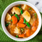 vegan Irish stew in white bowl over green kitchen towel