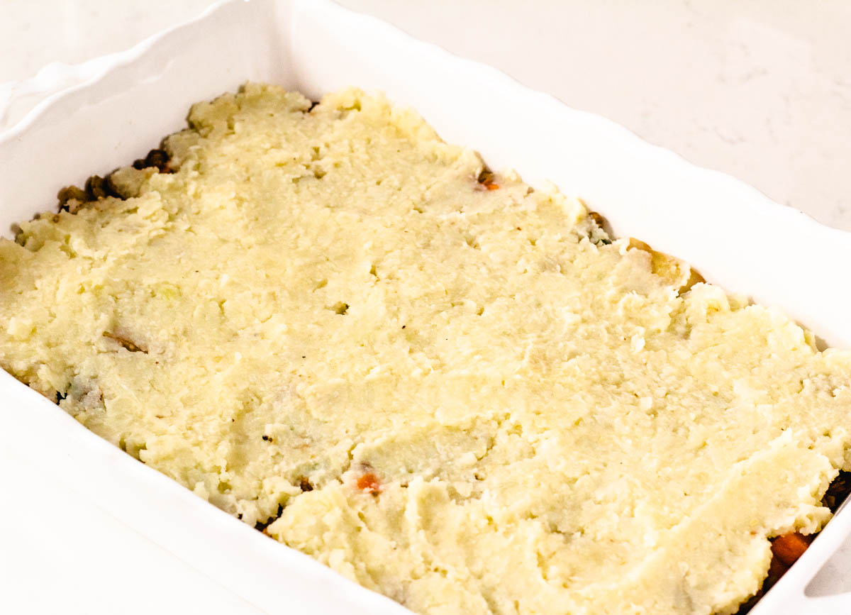 Pre-cooked lentil shepherd's pie in baking dish topped with mashed potatoes.