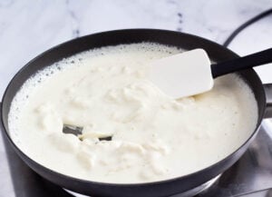 white liquid with solid clumps in pan