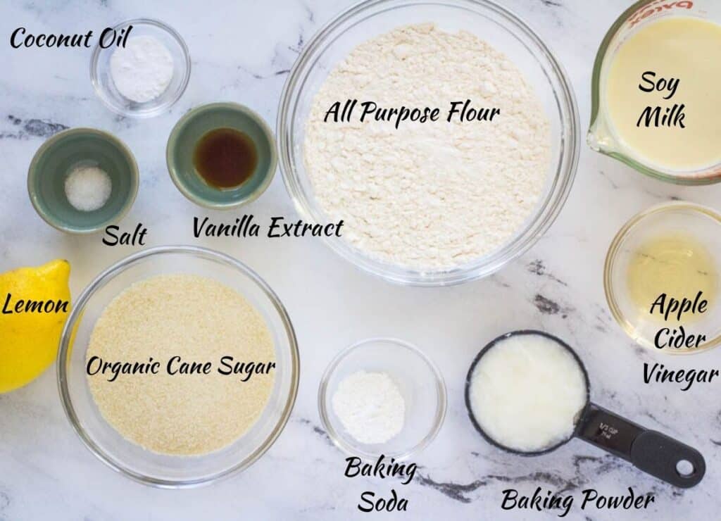 Ingredients for vegan lemon cupcakes: baking powder, baking soda, sugar, salt, vanilla extract, flour, coconut oil, apple cider vinegar, soy milk.