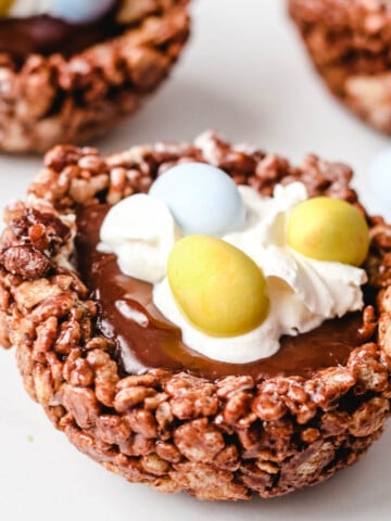 birds nest cookies with chocolate rice cereal nest, gilled with chocolate ganache and topped with whipped cream and candy eggs