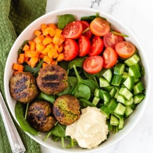 falafel plate with hummus, cucumber, tomatoes, carrots, and spinach