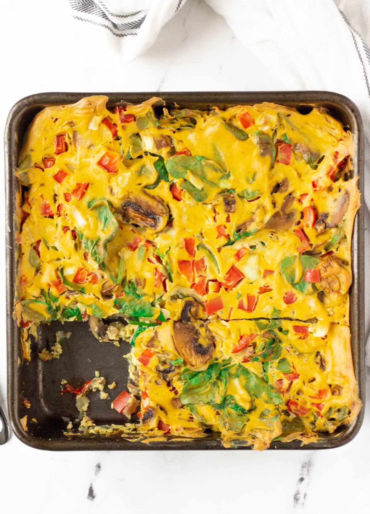 vegan breakfast egg casserole with mushrooms, peppers, and spinach
