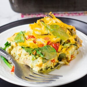 vegan breakfast casserole slice on white plate with fork