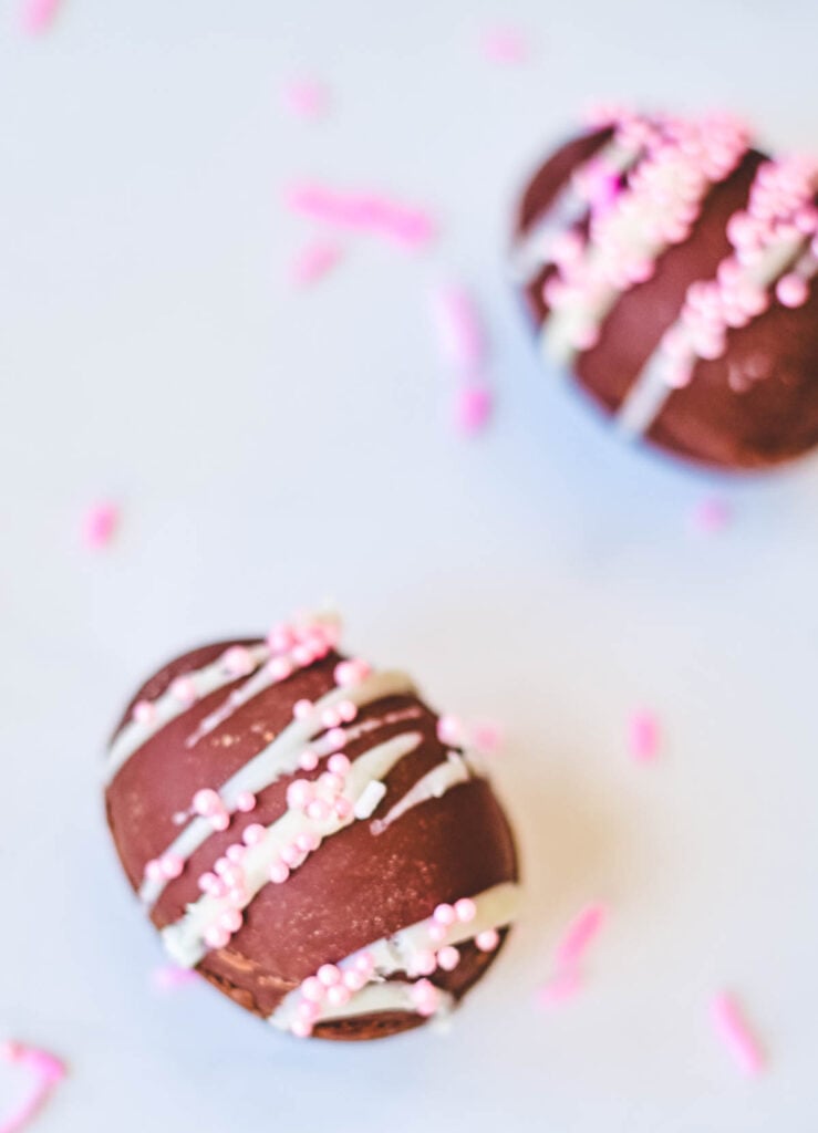 chocolate easter egg with white frosting drizzle and pink sprinkles