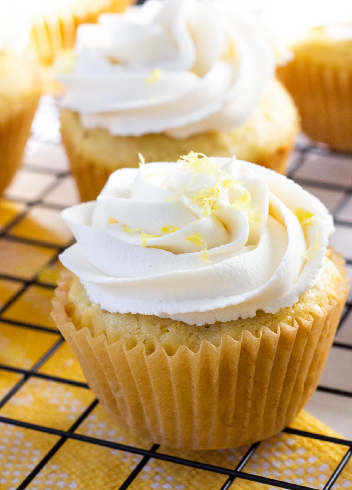 vegan lemon cupcakes topped with buttercream and lemon zest
