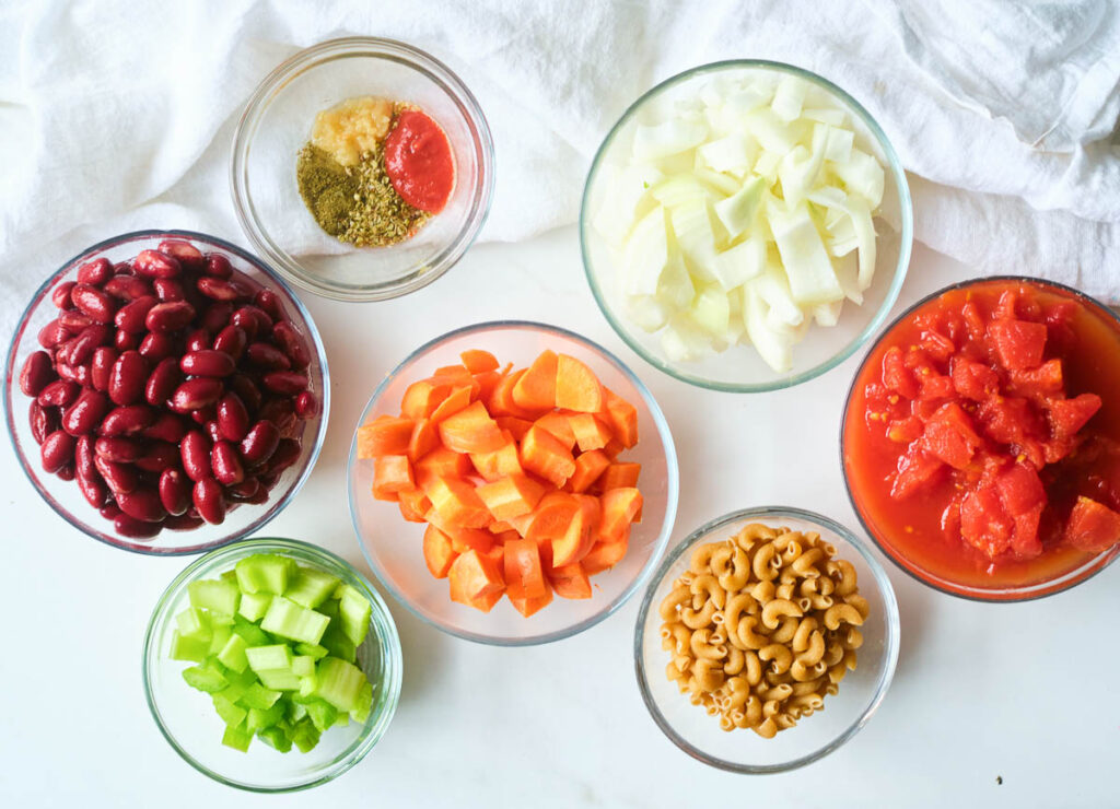 ingredients for instant pot minestrone soup: kidney beans, spices, celery, carrots, onions, diced tomatoes, and elbow macaroni