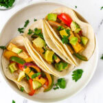 3 tofu fajitas in wide bowl topped with cilatro