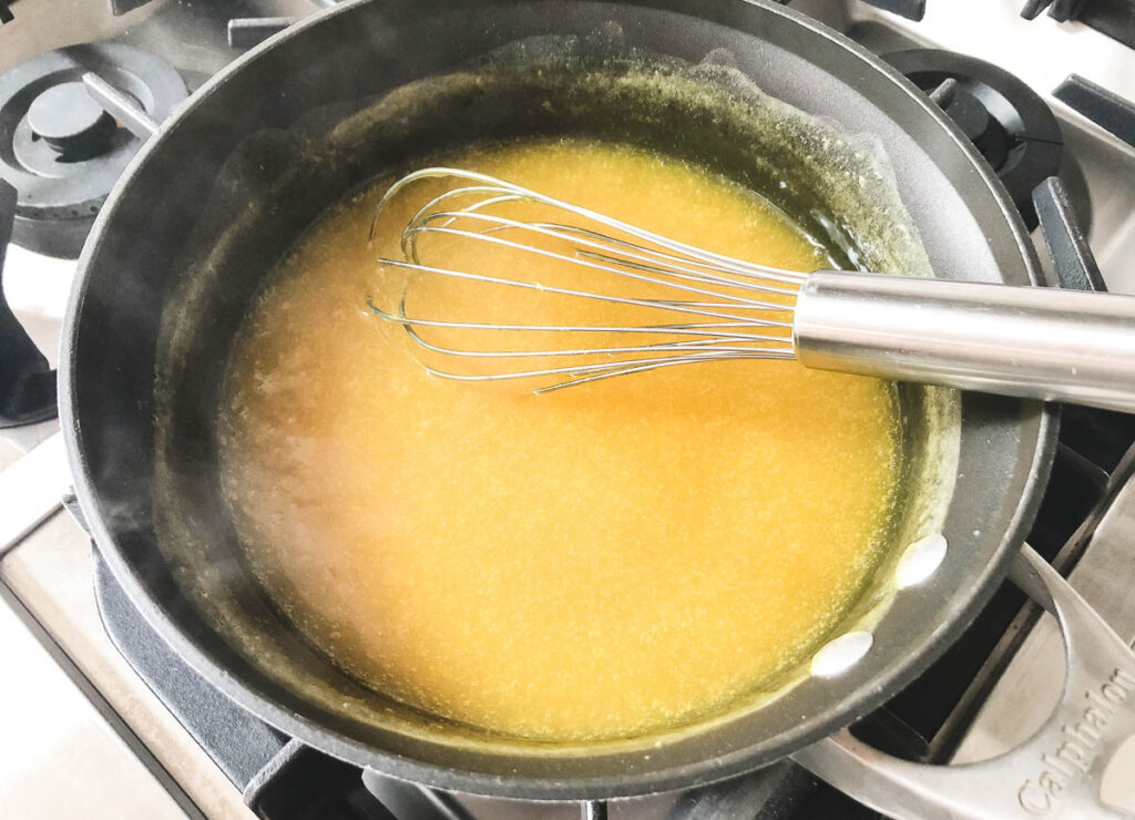 thickened lemon custard on stove with whisk