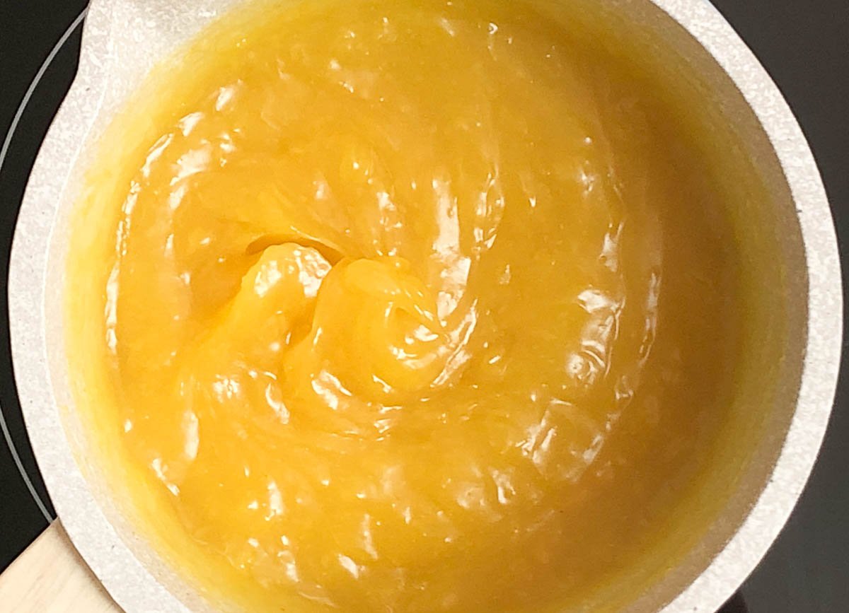 Thickened lemon filling in small saucepan to make vegan lemon curd.