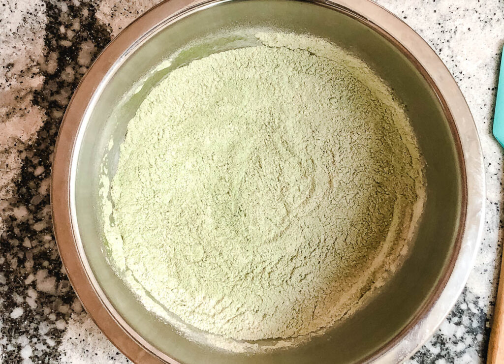 flour and matcha whisked together in bowl