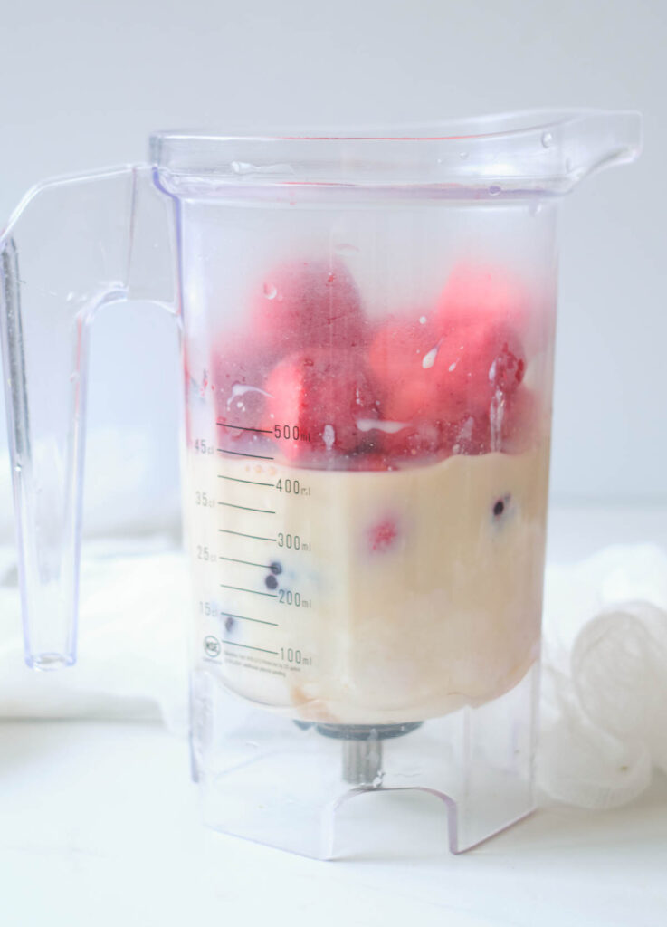 milk and frozen berries in blender