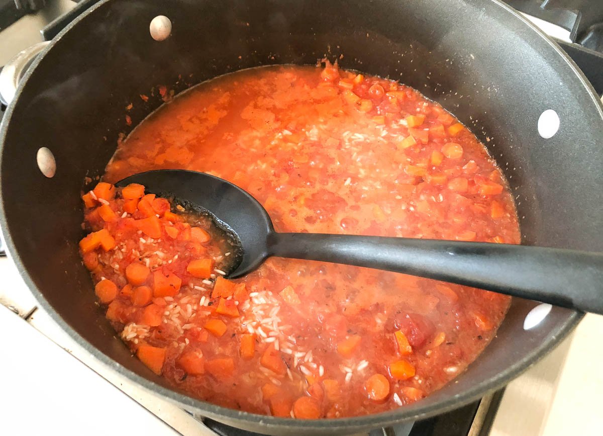 carrots, rice, puree tomatoes, and broth in a pot