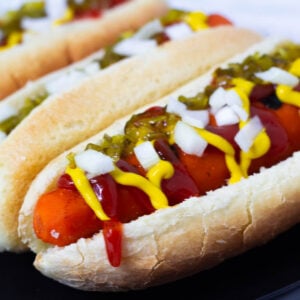 Carrot dogs in bun topped with ketchup, mustard, relish, and onion.