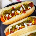 Carrot dogs on black plate.