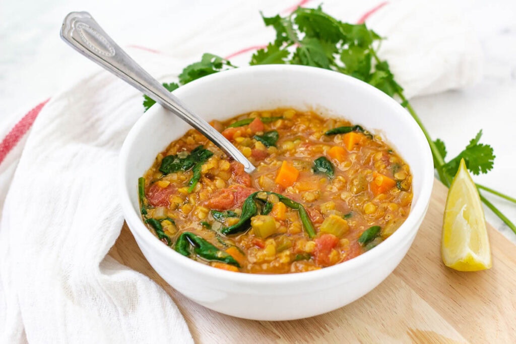 Bowl of lentil soup with spoon inside.