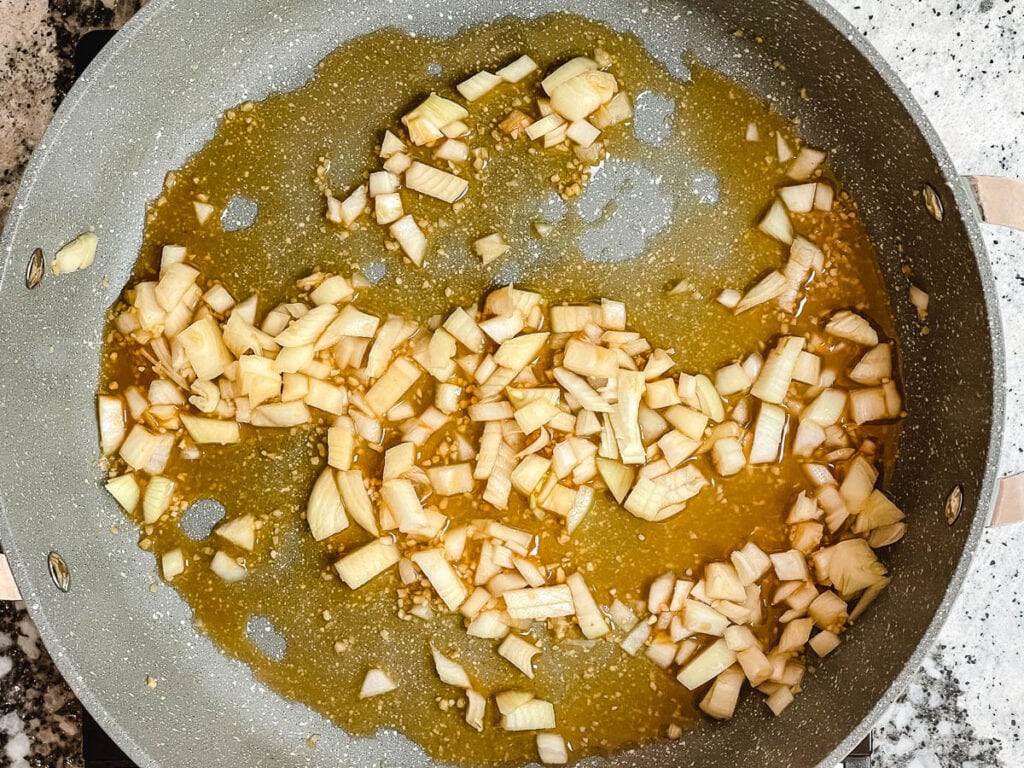 Diced onions in pot with vegetable stock.