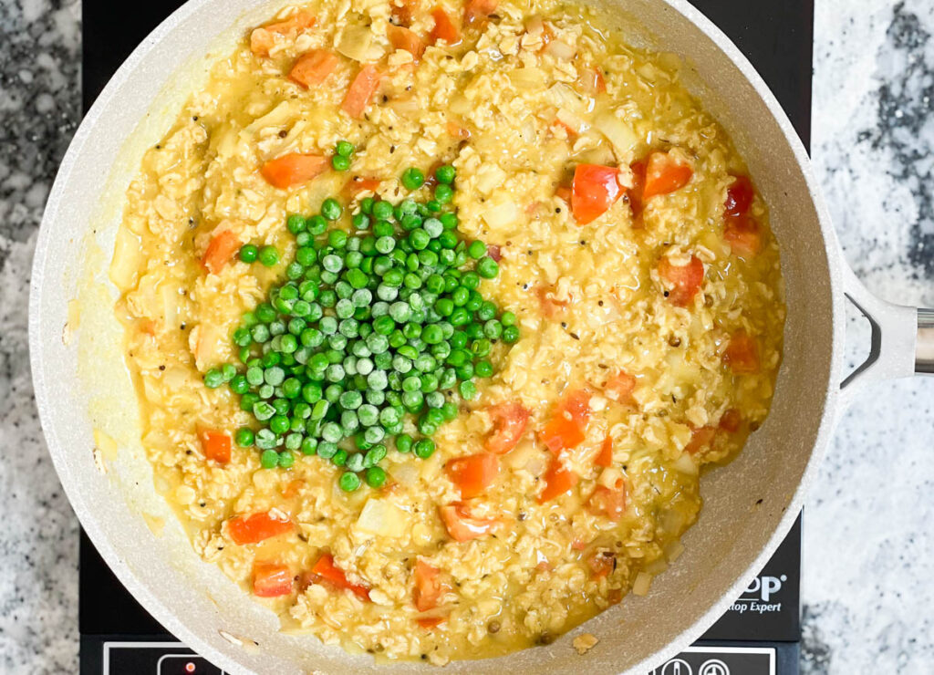 Frozen peas added to pot with oats and tomatoes.