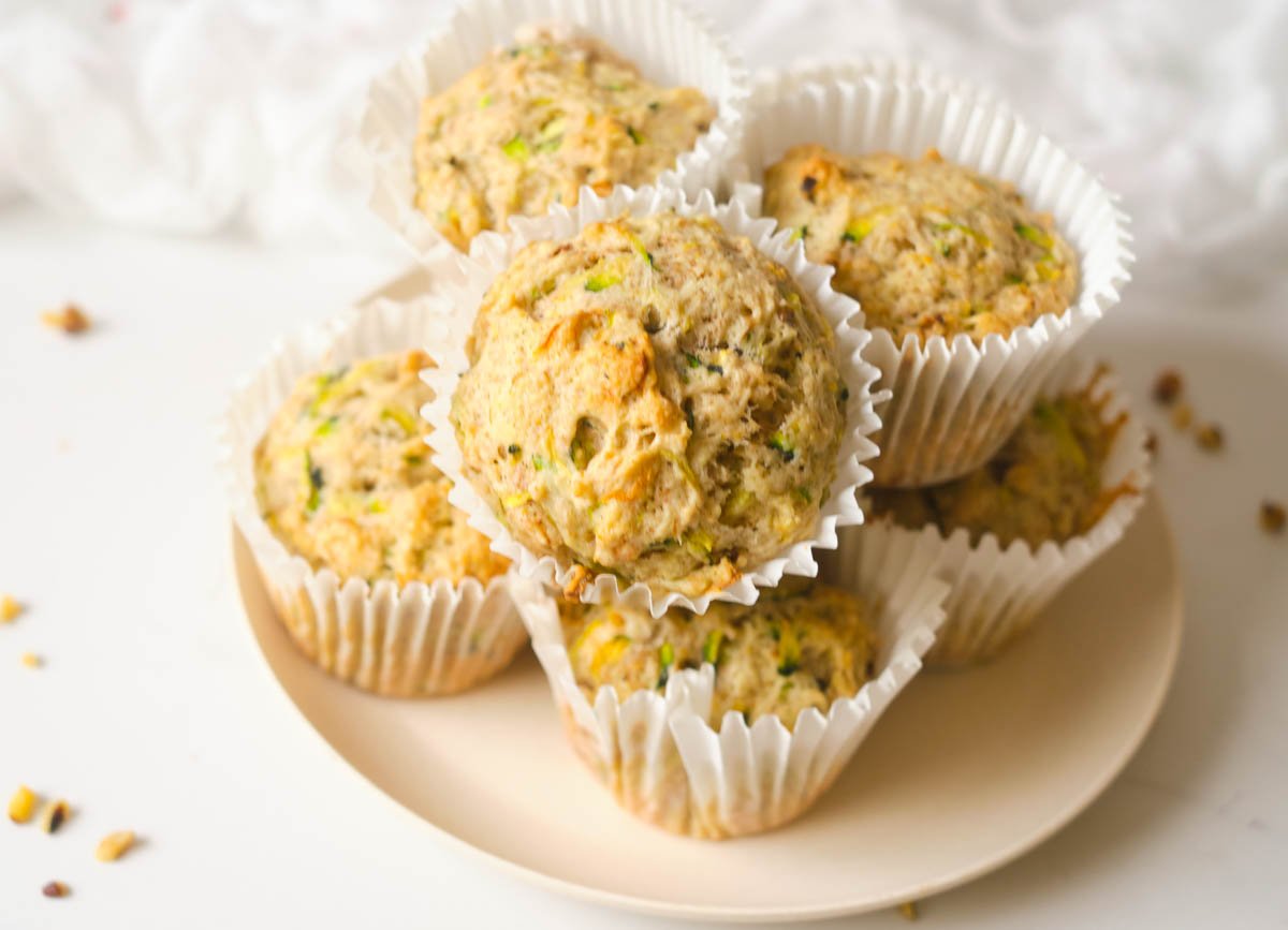 Several zucchini muffins on pink plate.