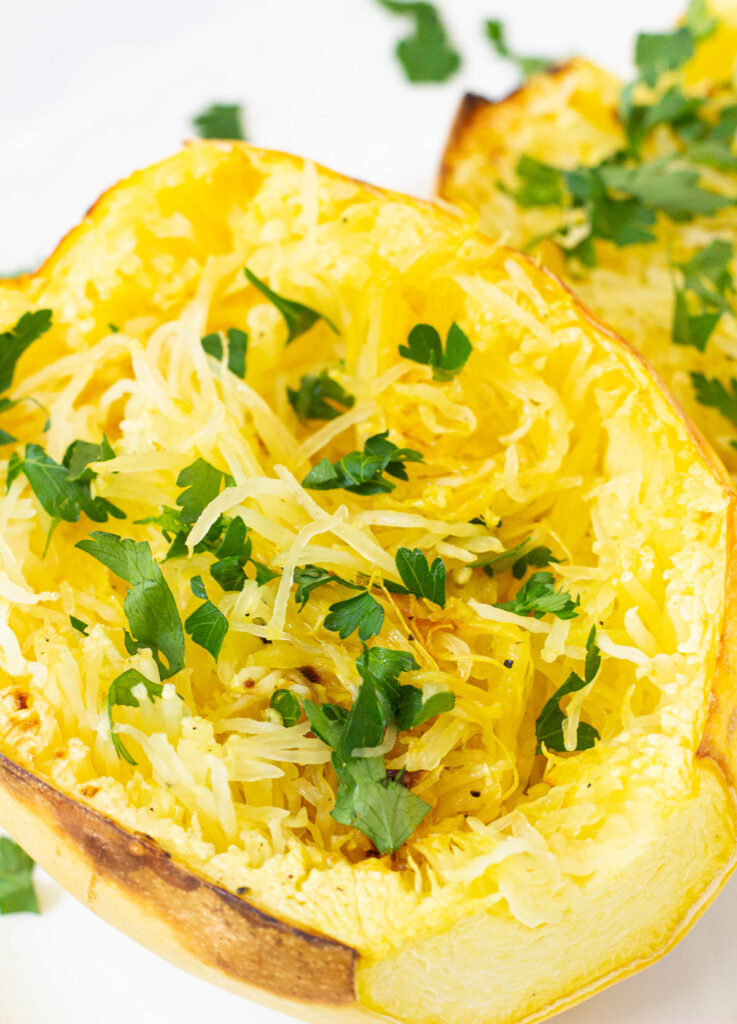 Cooked spaghetti squash half topped with parsley.