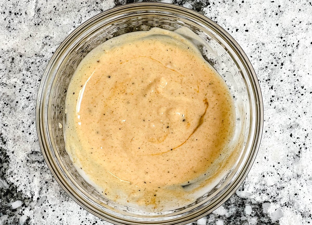 Creamy vegan curry dressing in glass bowl