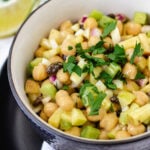 Chickpea curry salad in bowl topped with parsley.