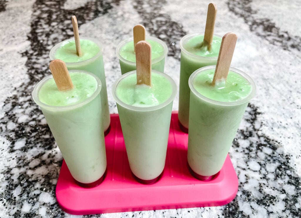 Frozen lime popsicles in molds.