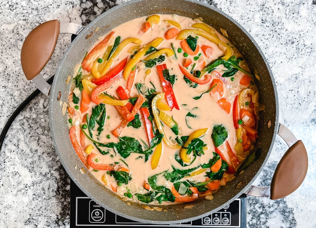 Vegan Thai red curry in pot with mixed vegetables.