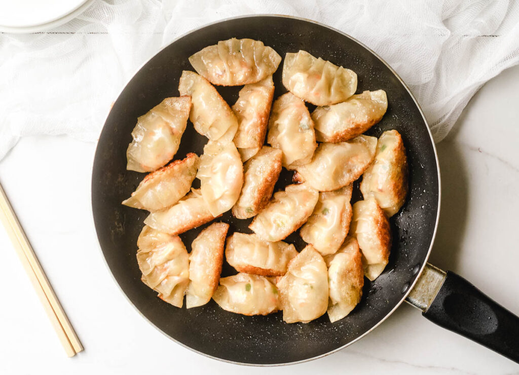 Crispy cooked dumplings in pan.