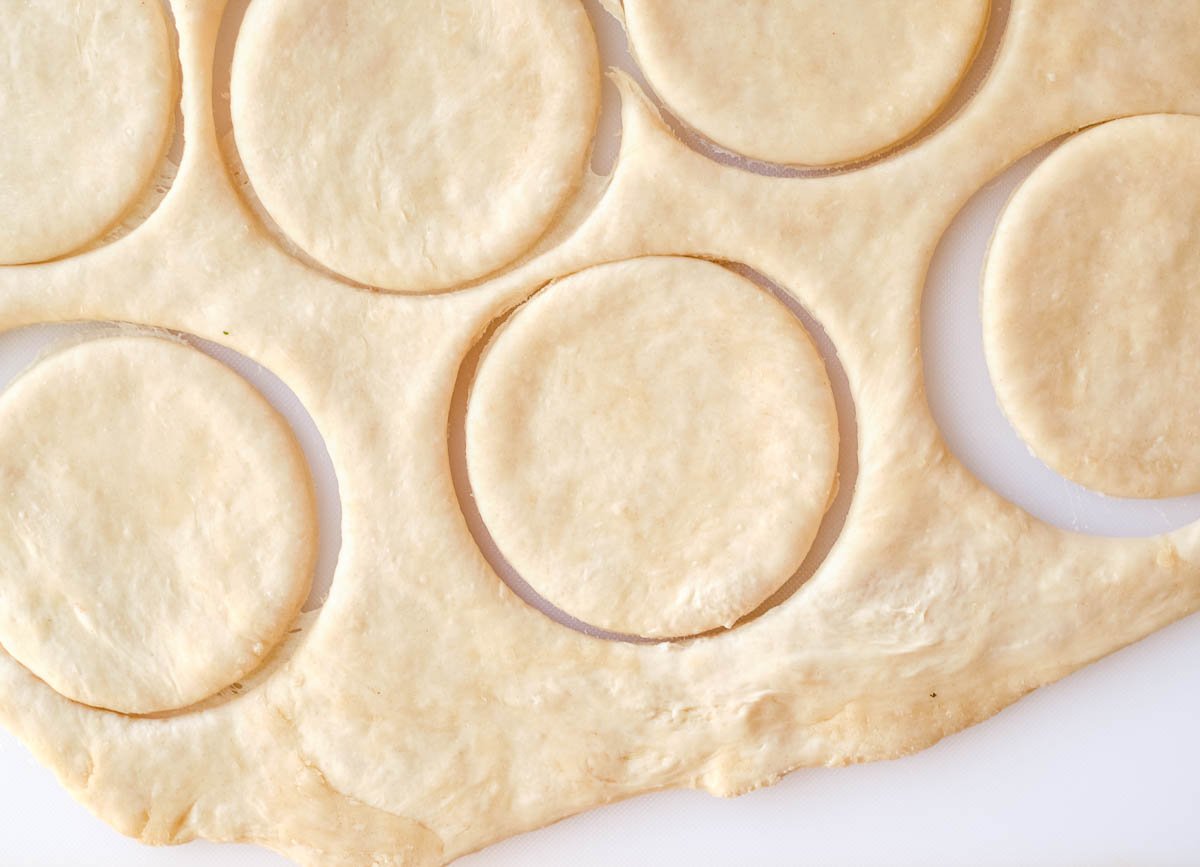 Four inch circles of dough cut out of dough.