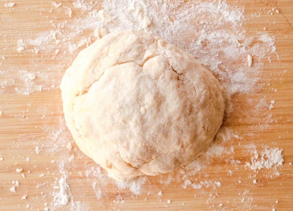 Ball of dough on floured cutting board.