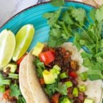 Vegan lentil tacos on turquoise plate.