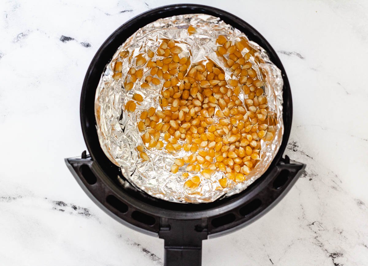 Popcorn kernels in the air fryer basket.
