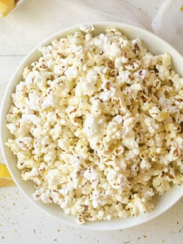 Air fryer popcorn in white bowl.