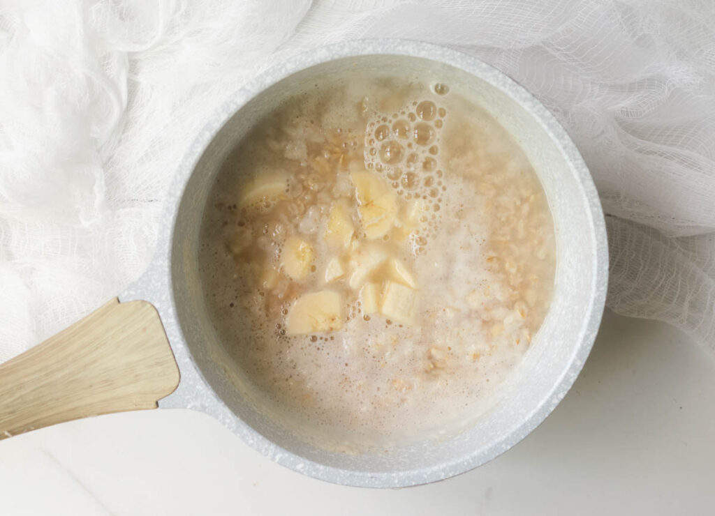 Chopped bananas added to oats and water in small saucepan.