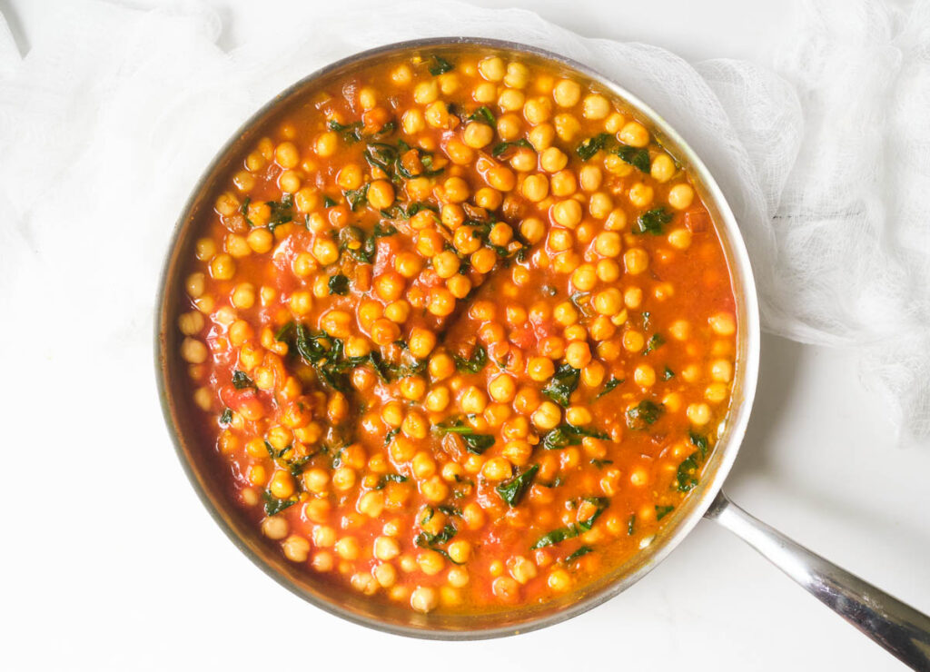 Chickpea curry spinach in pan.