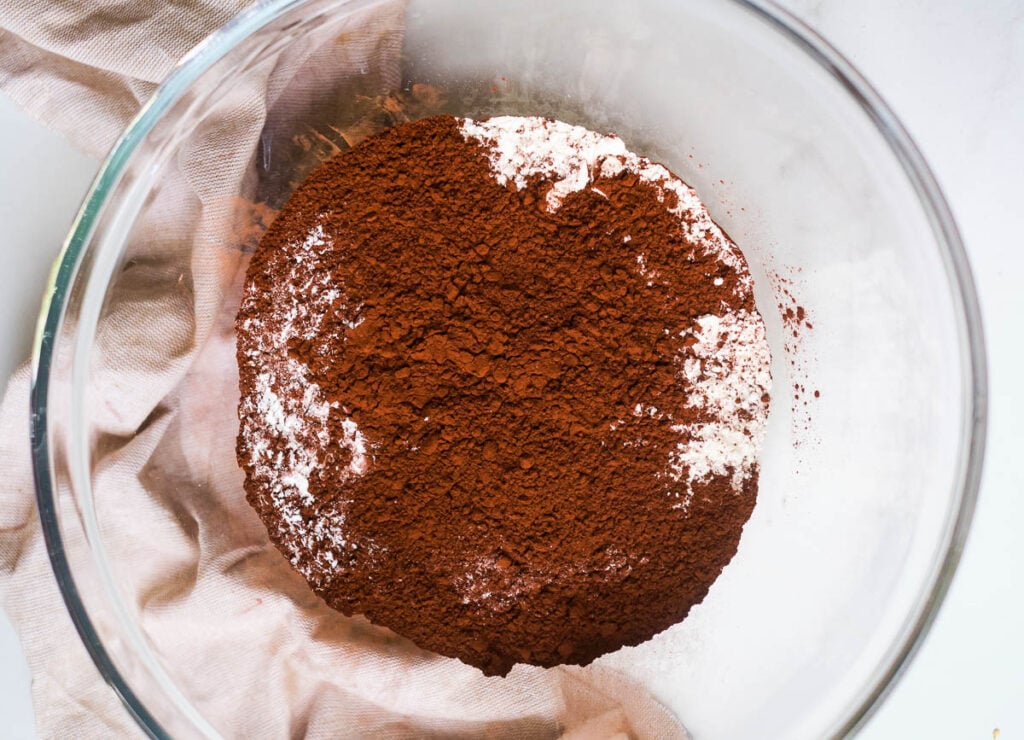 Cacao powder and flour in small white bowl.